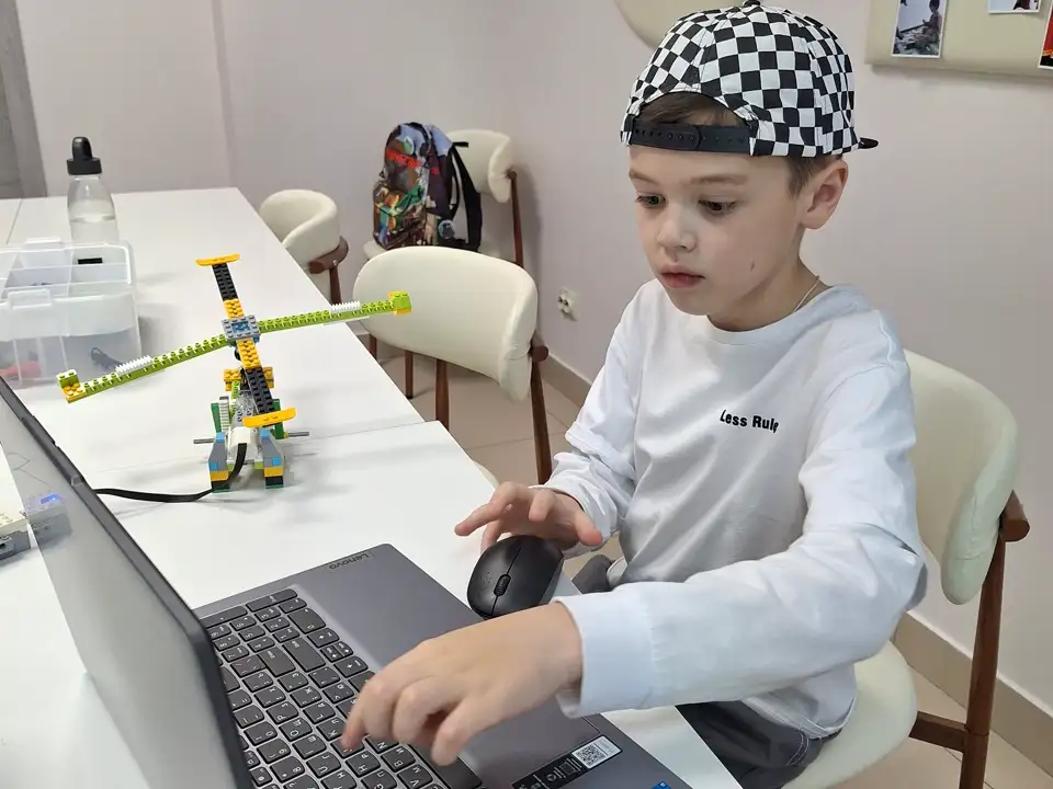 Ребёнок работает за компьютером над проектом Scratch