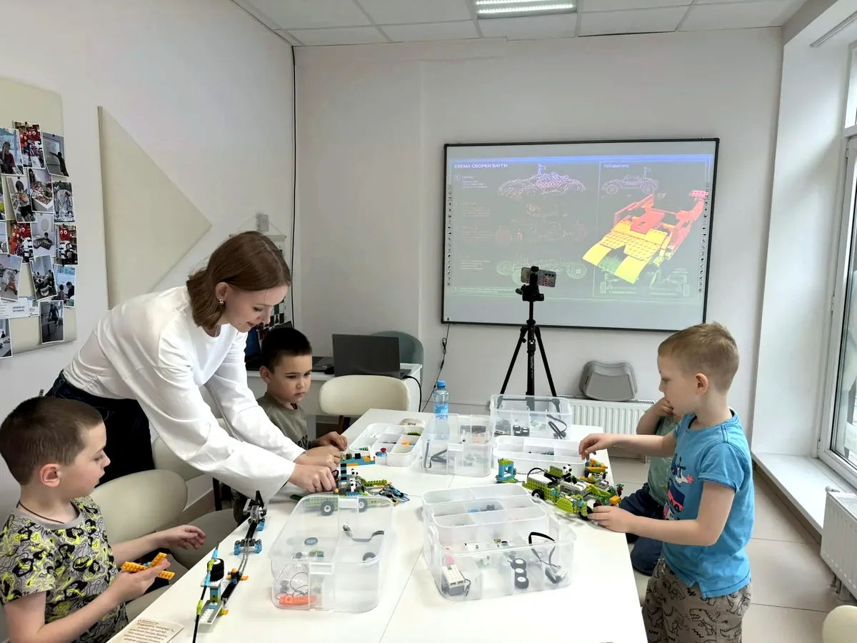 Педагог помогает ребёнку разобраться с задачей